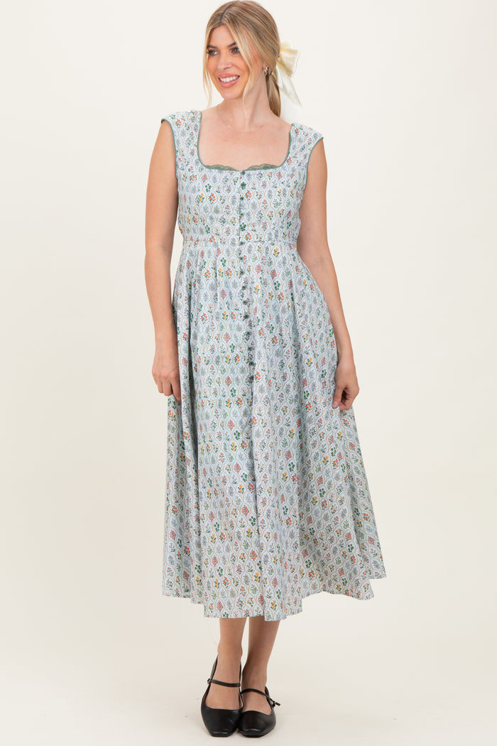 woman wearing a light blue floral midi dress with a square neckline and buttons down the front
