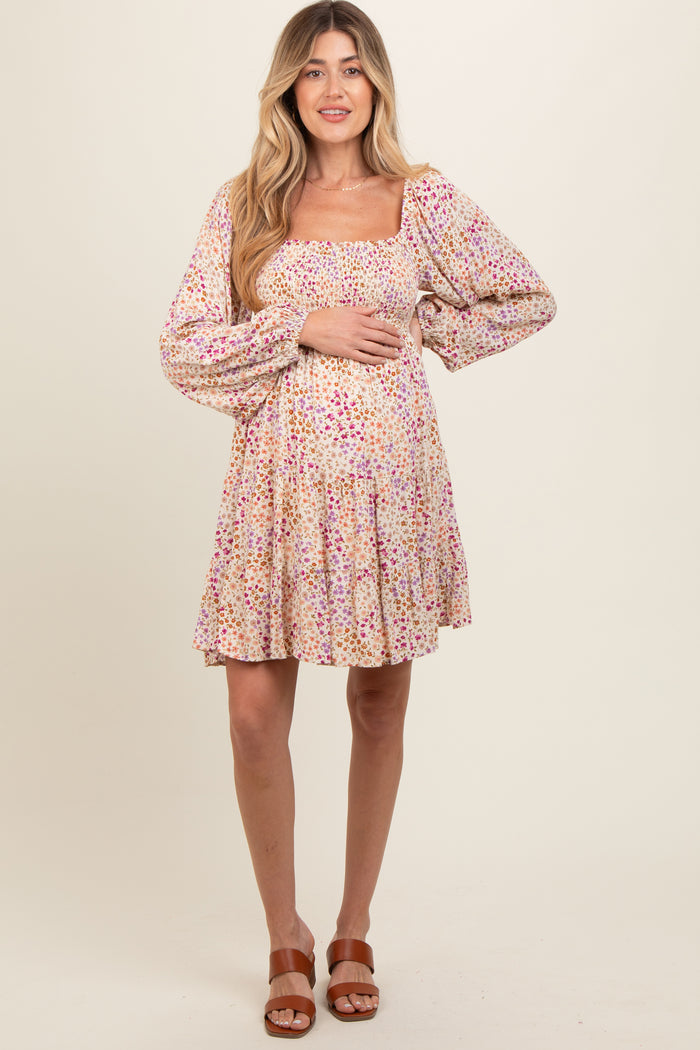 woman wearing a floral print maternity dress with puff sleeves and a baby bump