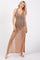 woman wearing a tan crochet maxi dress with side slits and a tie waist, standing barefoot