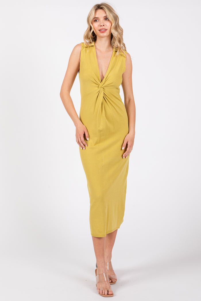 woman wearing a mustard yellow sleeveless midi dress with a twisted front detail