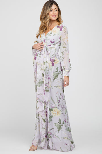 Pregnant woman wearing a light purple floral long sleeve maternity maxi dress with a waist tie