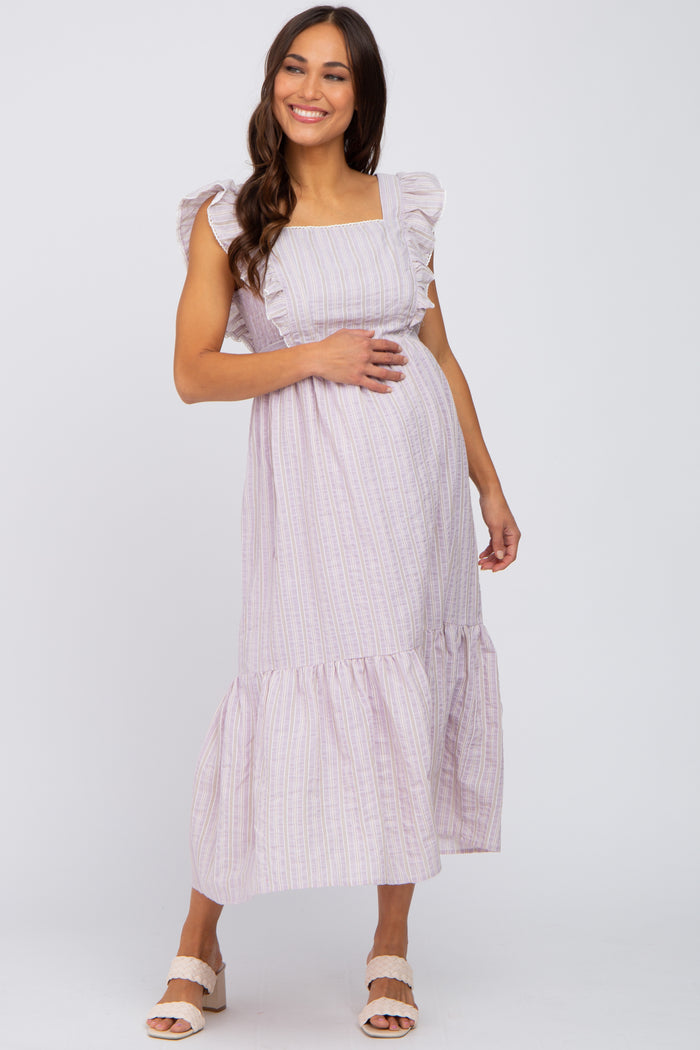 Smiling pregnant woman wearing a lavender striped maternity midi dress with ruffle sleeves and tiered hem