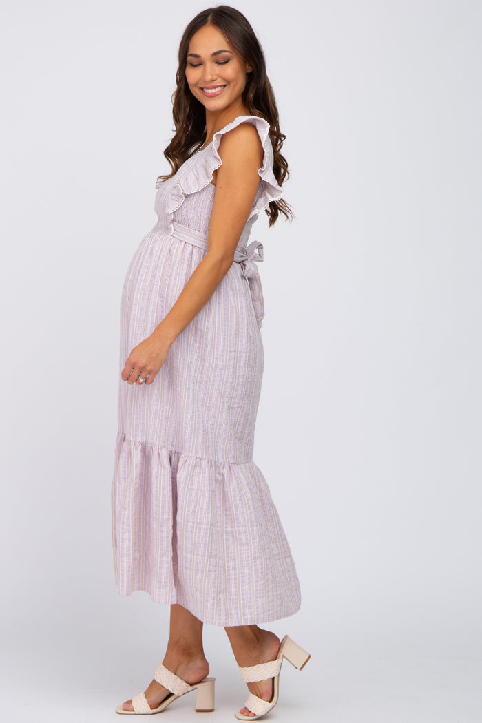 smiling pregnant woman wearing a lavender striped ruffle maternity midi dress and beige block heels