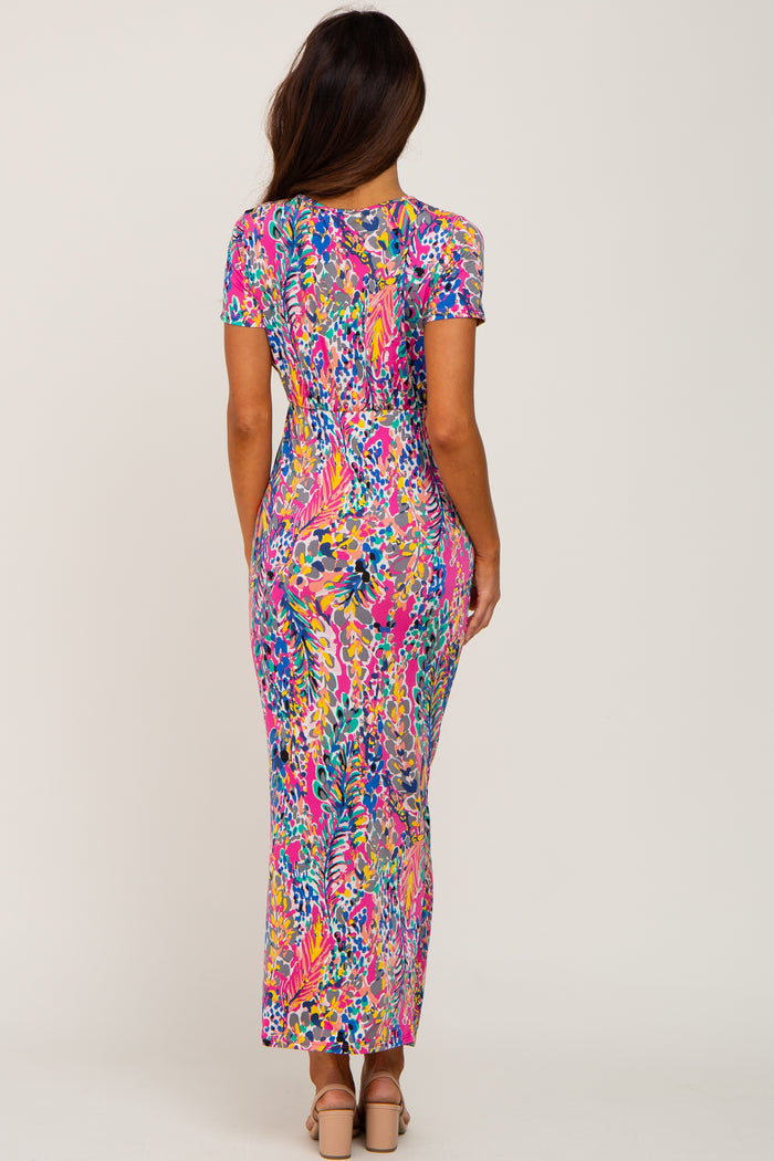 back view of woman wearing colorful pink floral print short sleeve maxi dress with tan block heels