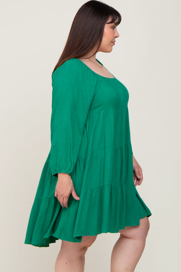 woman wearing a green tiered long sleeve dress in plus size, shown from the side