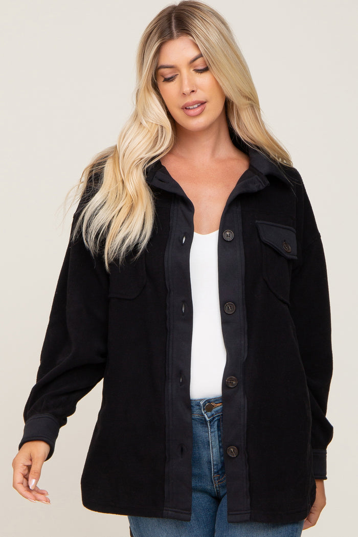 Woman wearing a black button-down fleece shacket over a white top and blue jeans