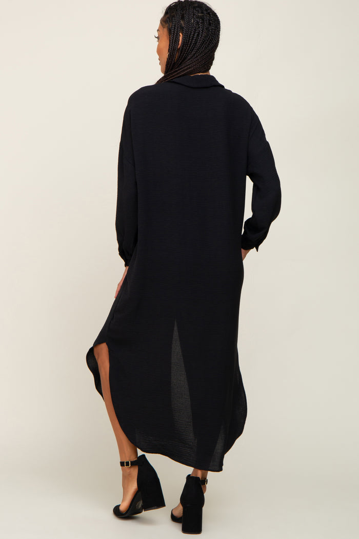 Woman from behind wearing a long black button down shirt dress and black block heel sandals