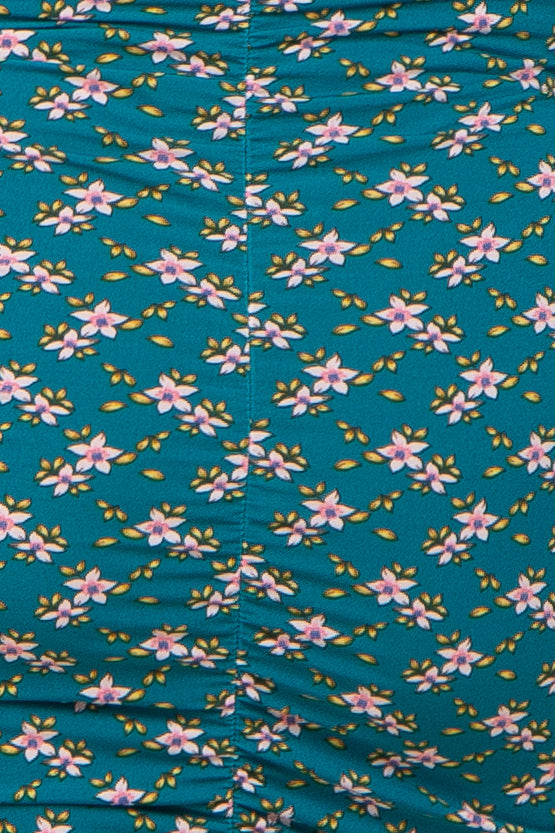 maternity wear in teal with a floral print featuring pink and yellow flowers, showing gathered detailing on the fabric