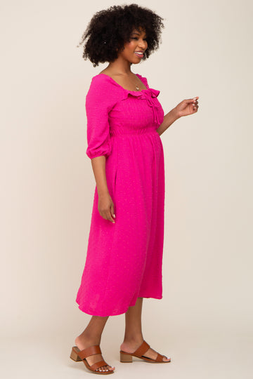 woman wearing a hot pink midi dress with puff sleeves and tie detail at the neckline