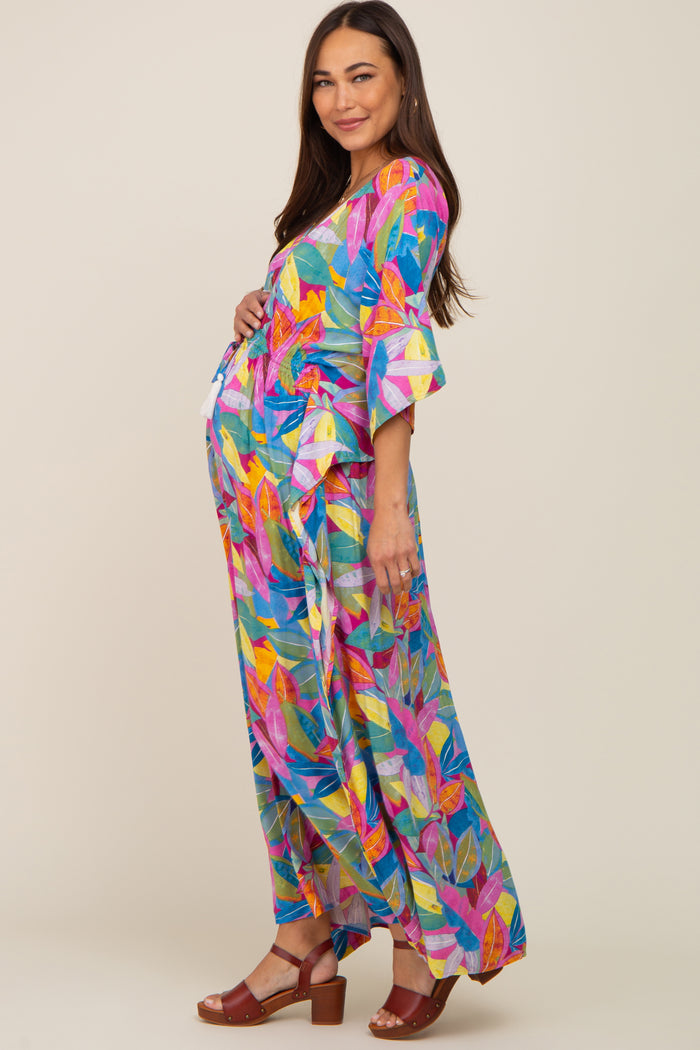 woman wearing a vibrant multi-colored maternity dress with three-quarter sleeves and a baby bump visible