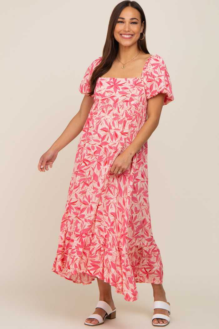 woman wearing a pink and white floral puff sleeve maternity midi dress with white sandals