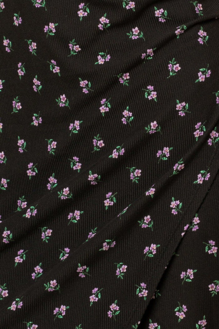 close up of black ribbed fabric with small purple floral print pattern